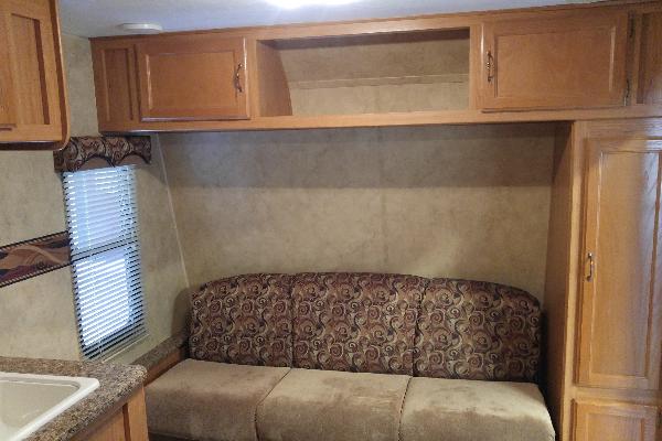 Couch converts to twin bed with lots of cabinets and storage above and on side of couch