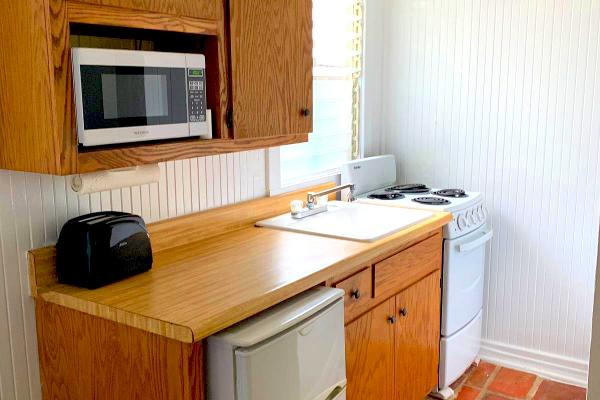 Kitchen with microwave, refrigerator, oven, & stove.