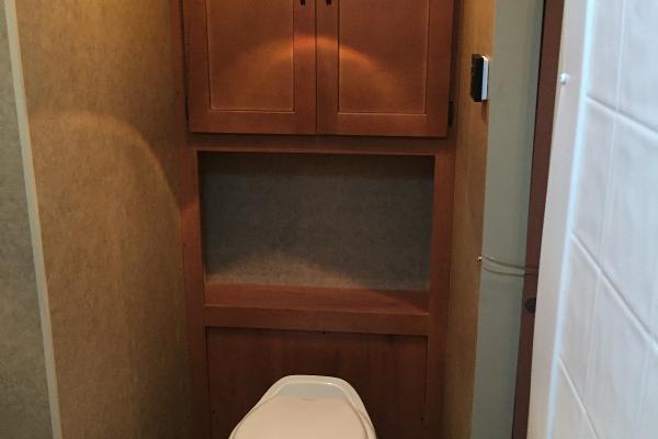 Bathroom Toilet with cabinet space behind for extra storage