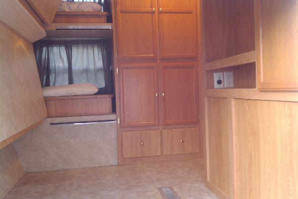 Front bunk bedroom with large entrance door for storage (bunk beds fold up for addt'l storage while traveling)